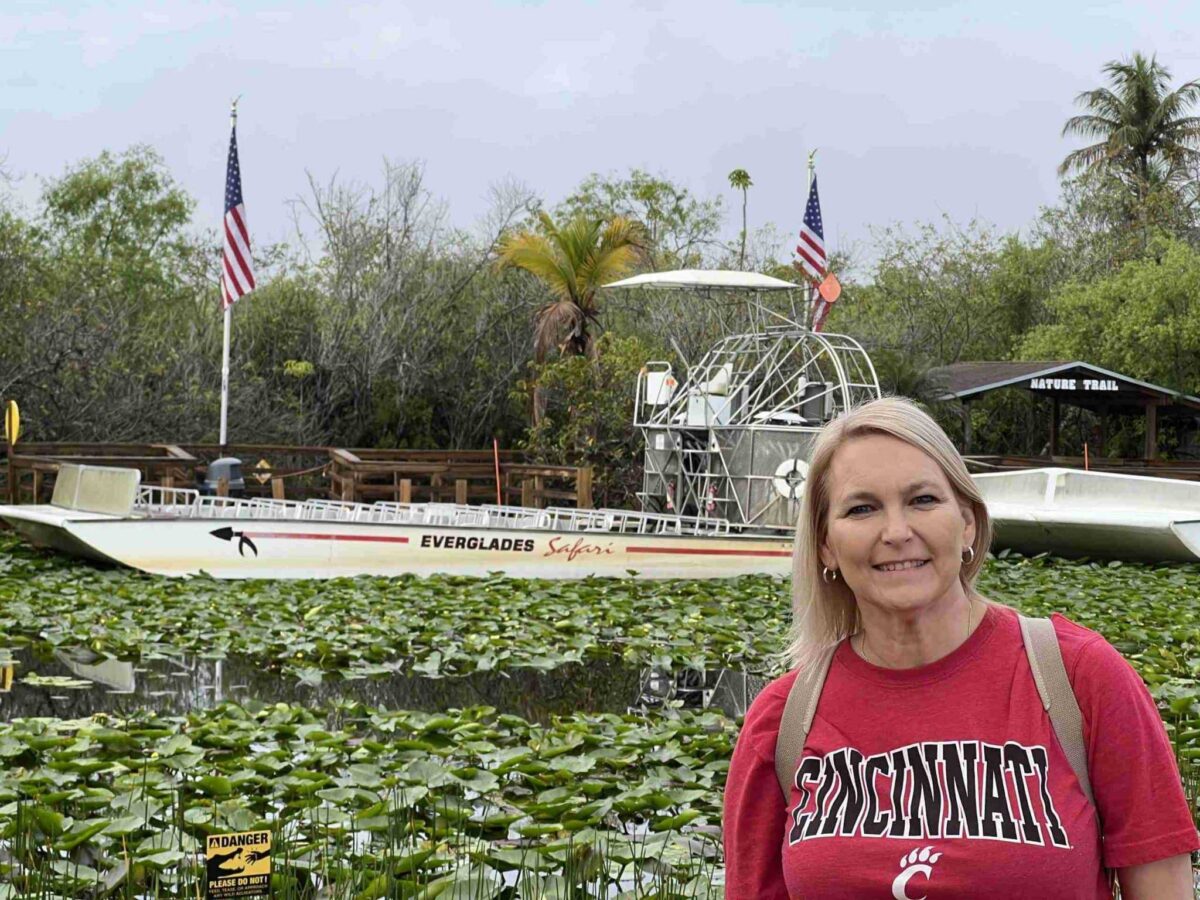 A woman smiles in front of an Everglades airboat