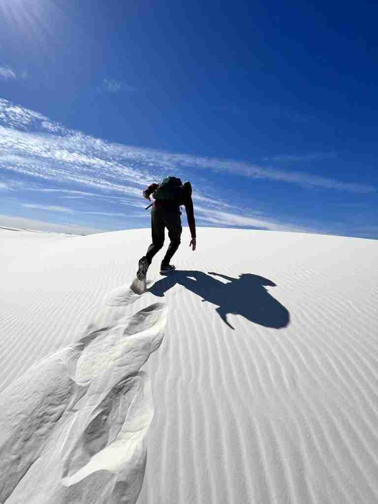 Climbing a sand dune on Alkali Flat Trail in White Sands