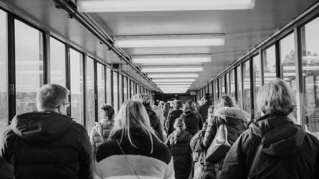 grayscale photo of people waiting in line
