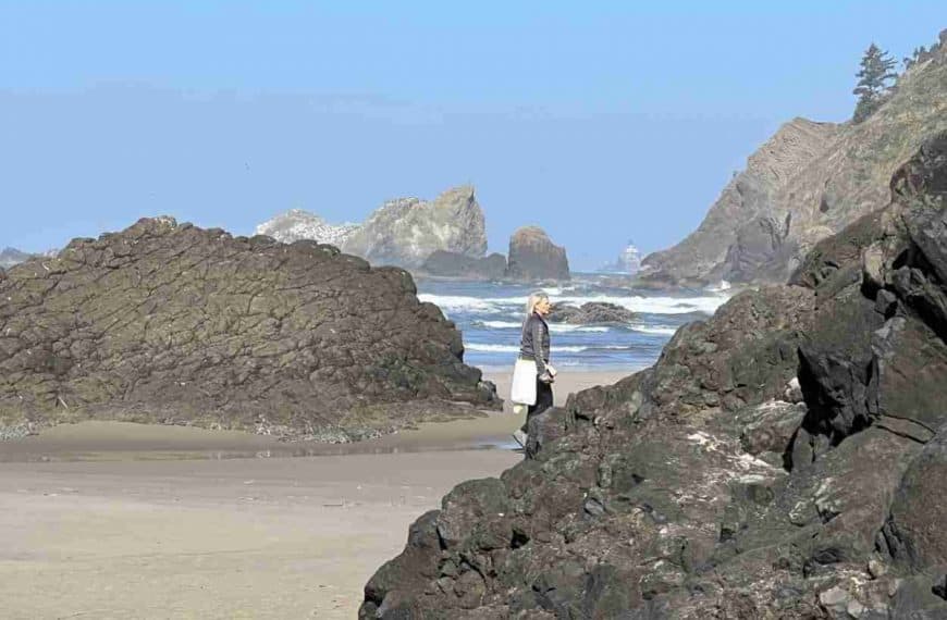 Rocky shoreline of Oregon Coast with lighthouse in background