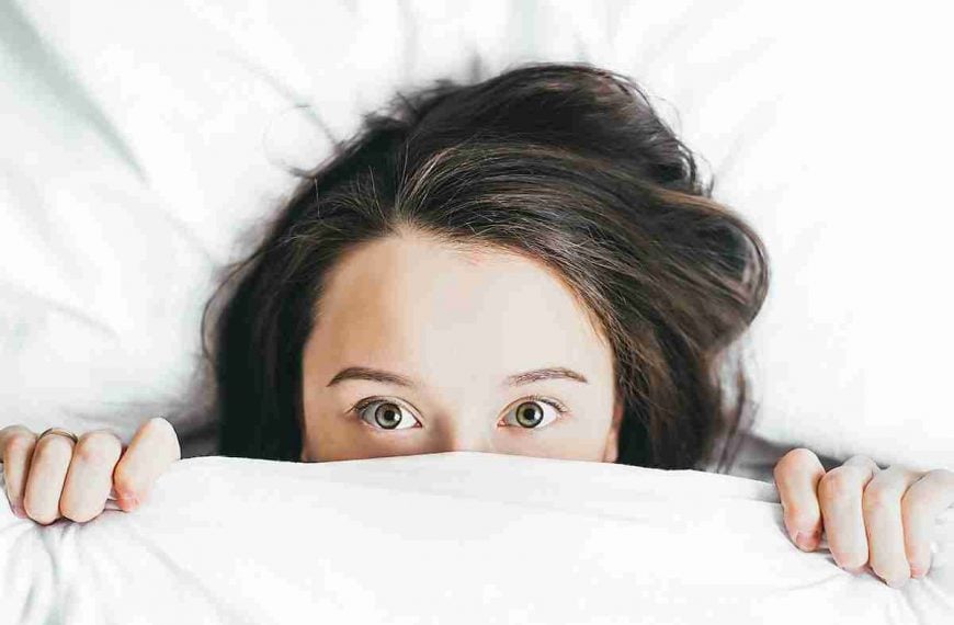 woman covering her face with blanket