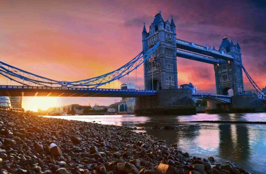 a bridge over a body of water with a sunset in the background