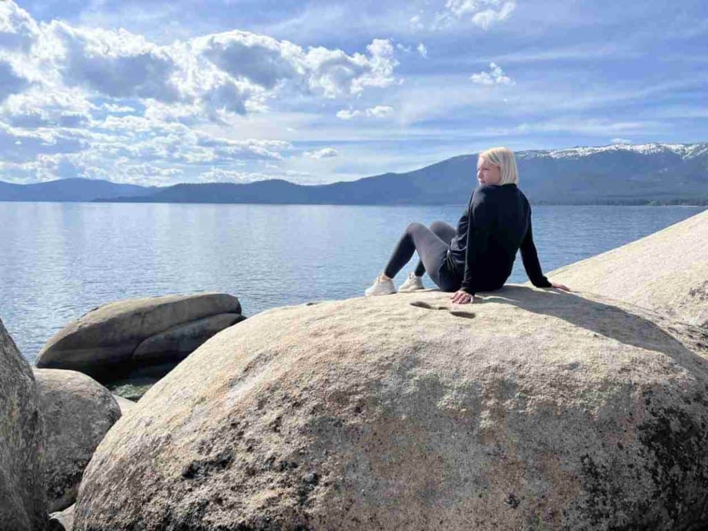 Sitting on a boulder at Lake Tahoe and enjoying the view