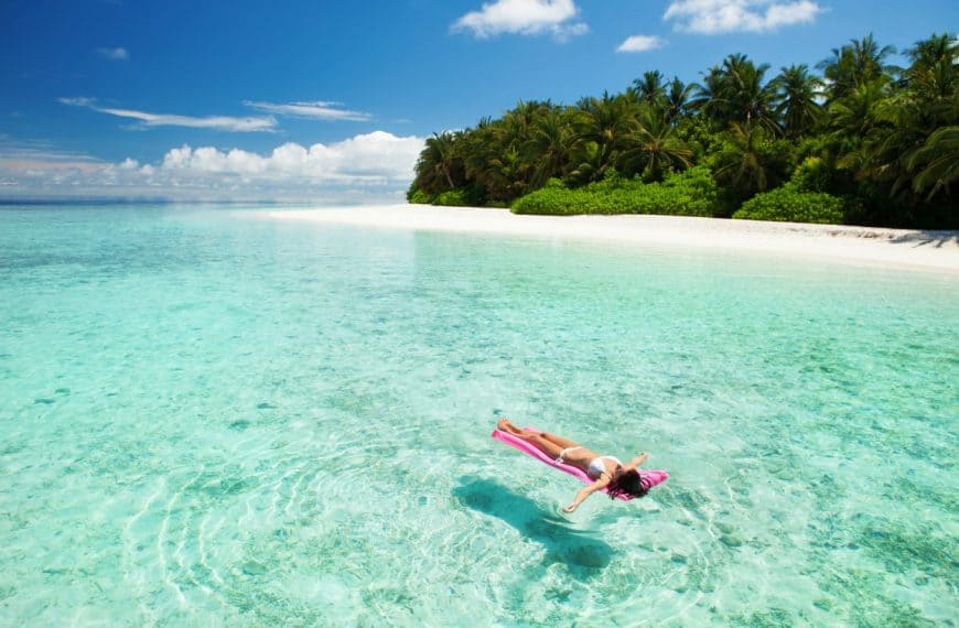 A woman floats on a raft at a beach resort