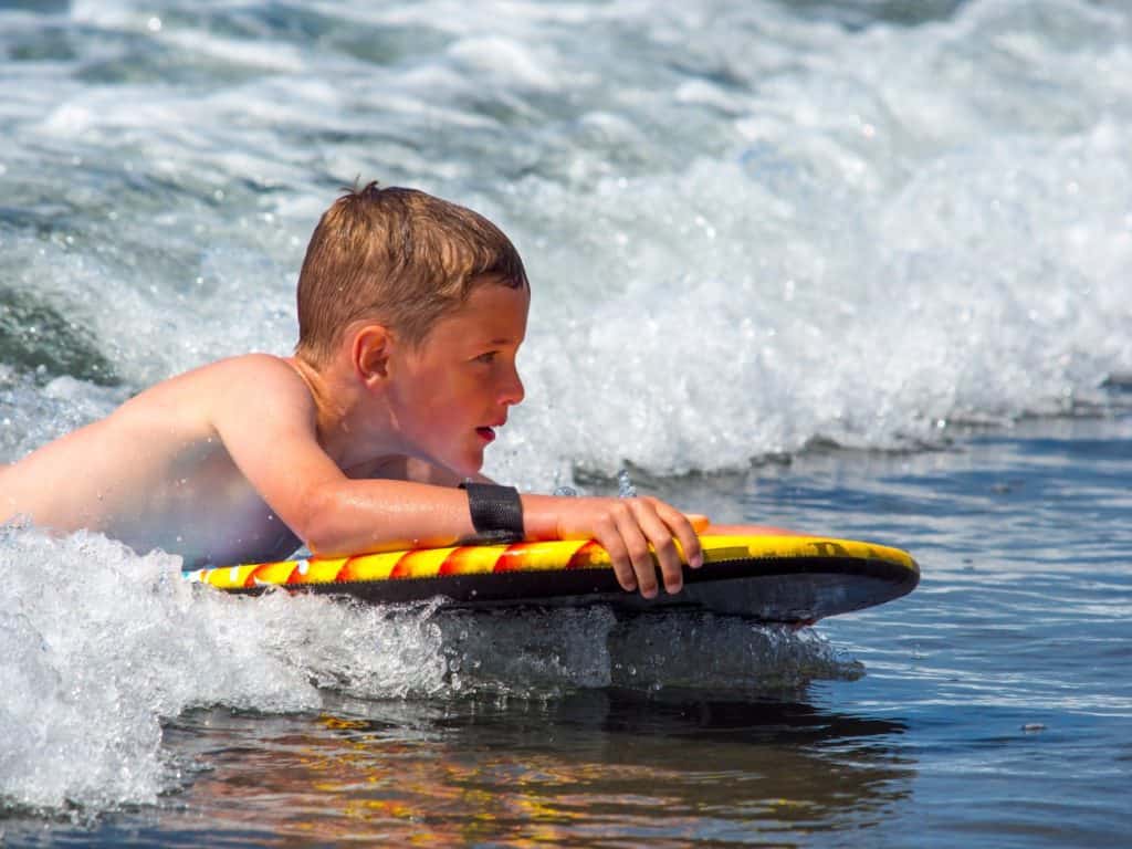 A boy rides a boogie board