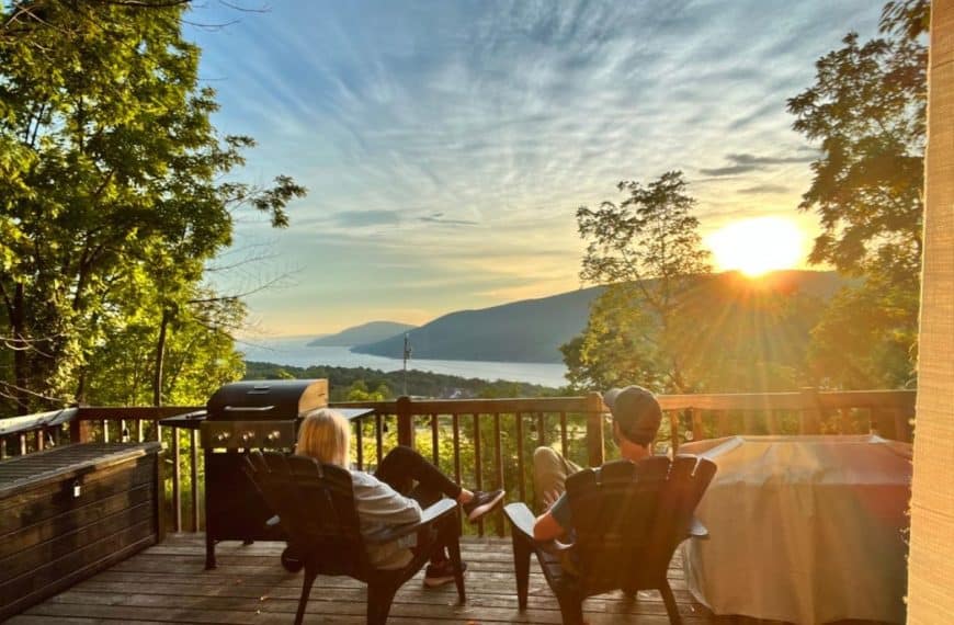 A man and woman sit on a deck, enjoying the view of the Finger Lakes in upstate New York.