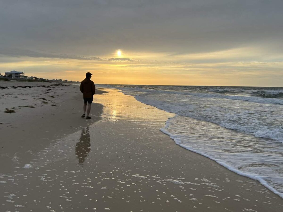 Scott McConkey of the Miles with McConkey Travel Blog walks the beach just after sunrise at St. George Island.