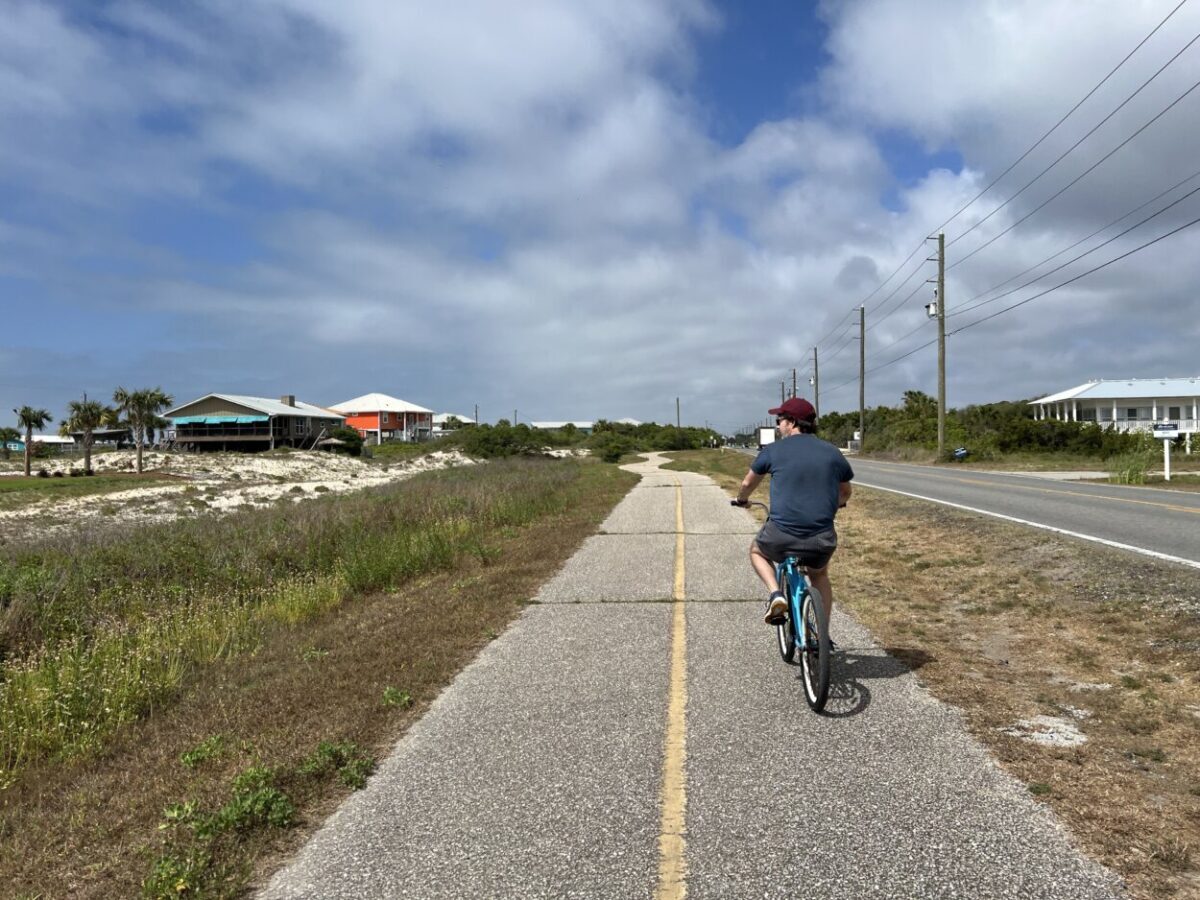 Scott McConkey of the Miles with McConkey Travel Blog rides a bike on a bike path in St. George Island
