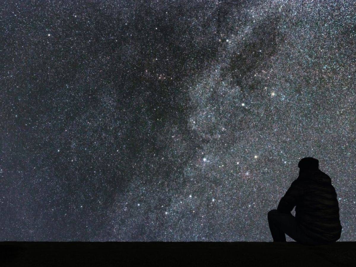 A man looks at the stars in the night sky.