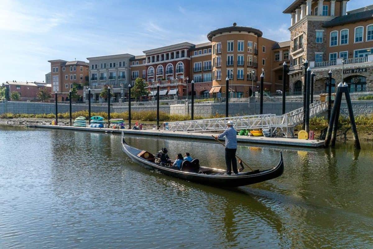 A gondolier guides a gondola toward the Napa Valley Dock.