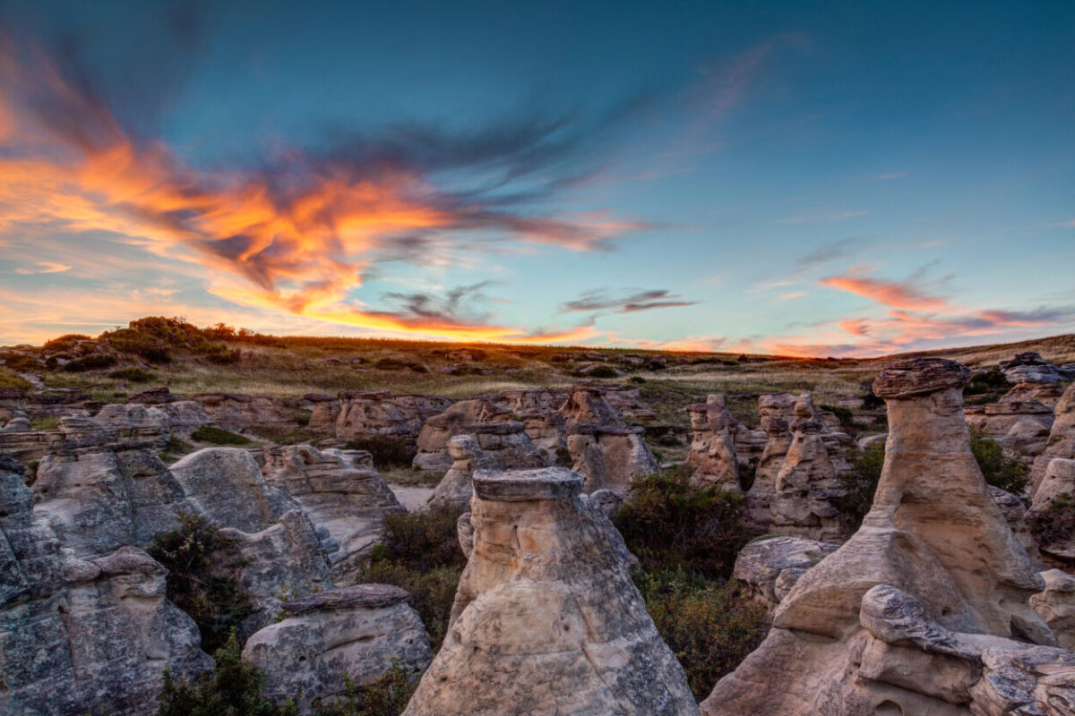 The sun sets over hoodoo badlands