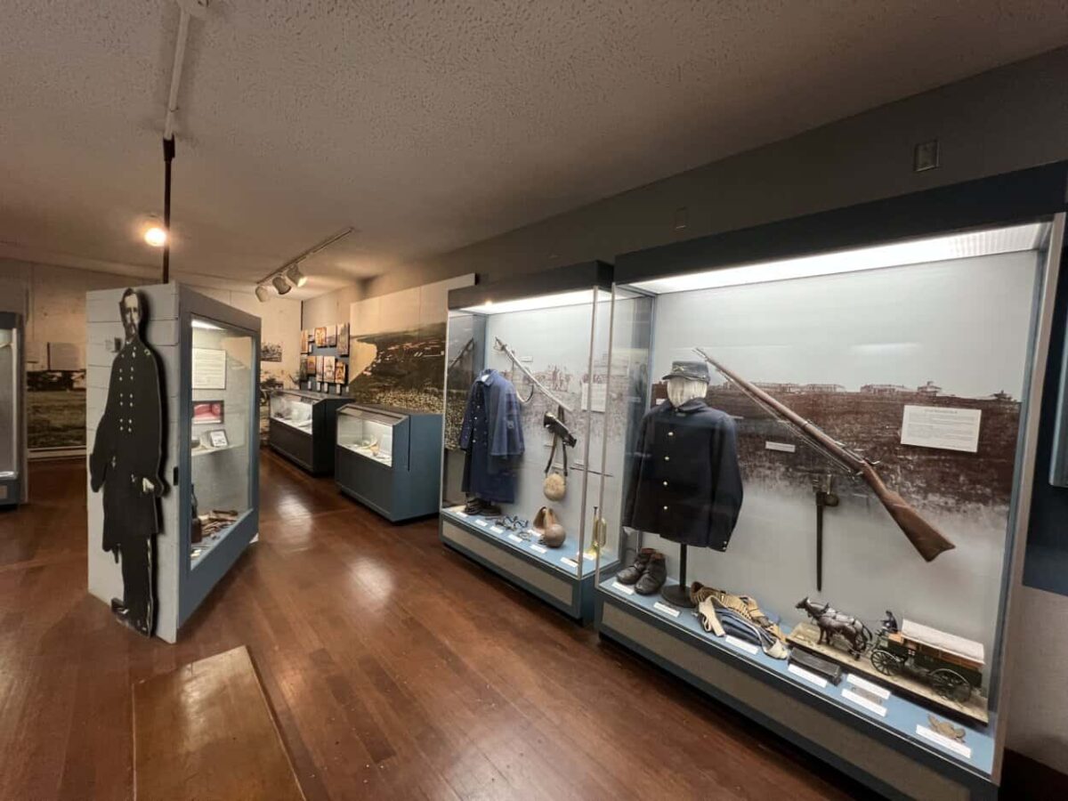 Exhibits with soldier uniforms, rifles, and other artifacts from the United States cavalry and infantry in the 1870s