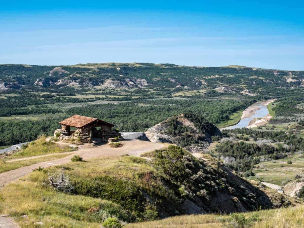 A stone shelter sits along the edge of an overlook above the Little Missouri River