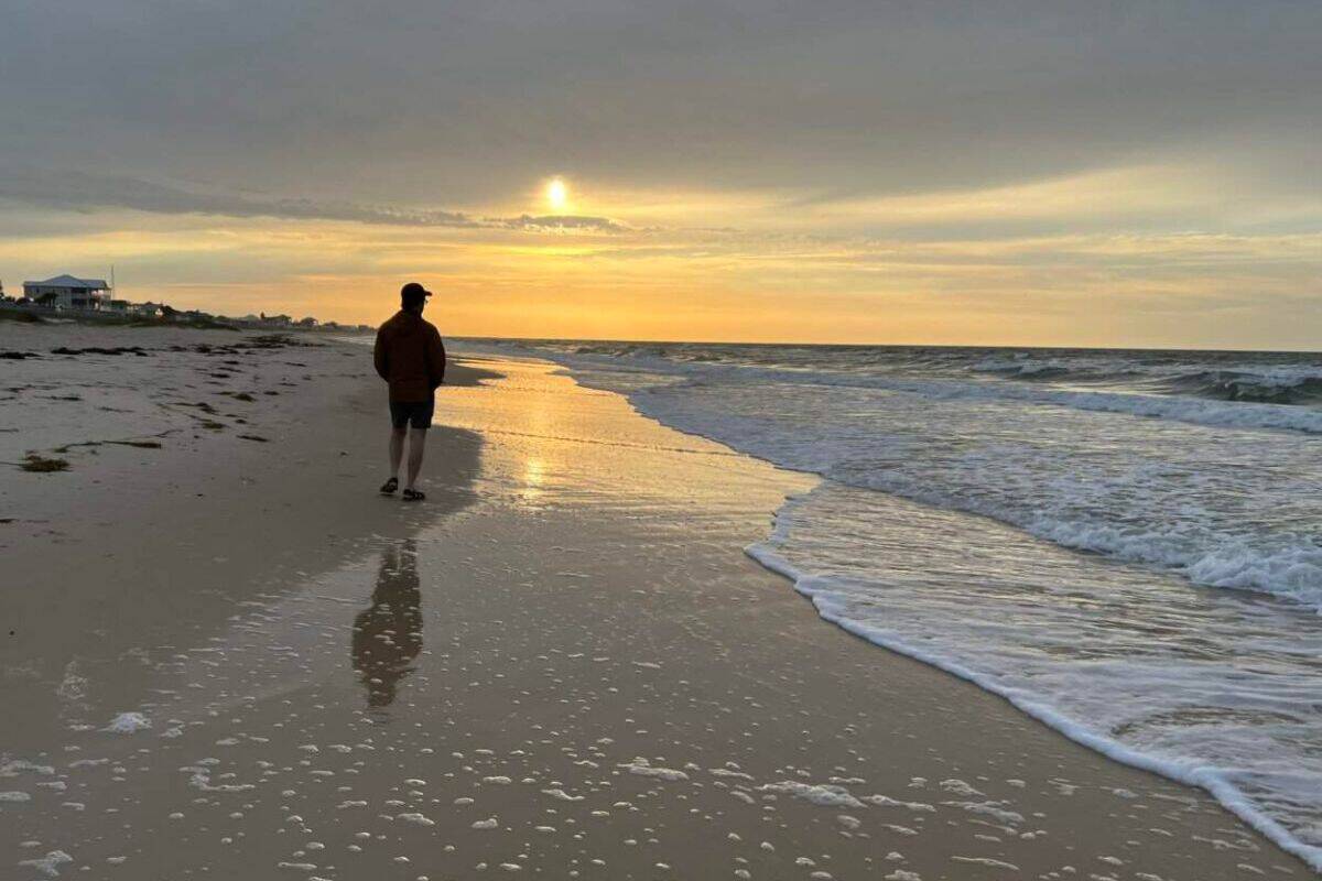 Scott McConkey of the Miles with McConkey Travel Blog walks the beach just after sunrise at St. George Island.