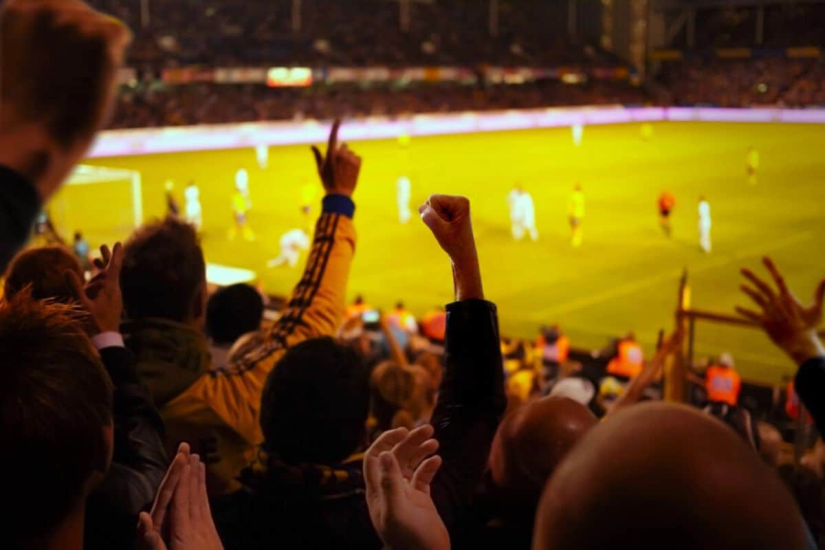 Fans cheer at a soccer stadium