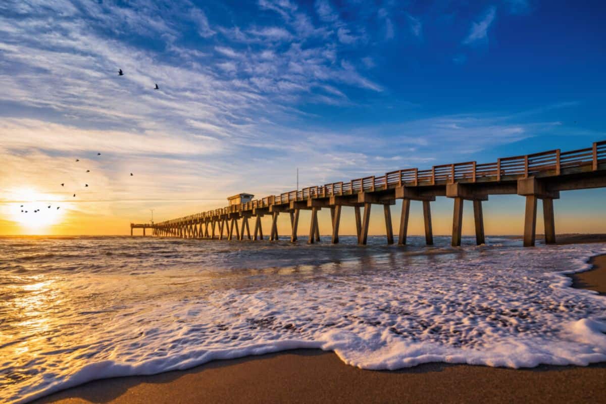 The sun sets behind the pier at Venice Beach, FL