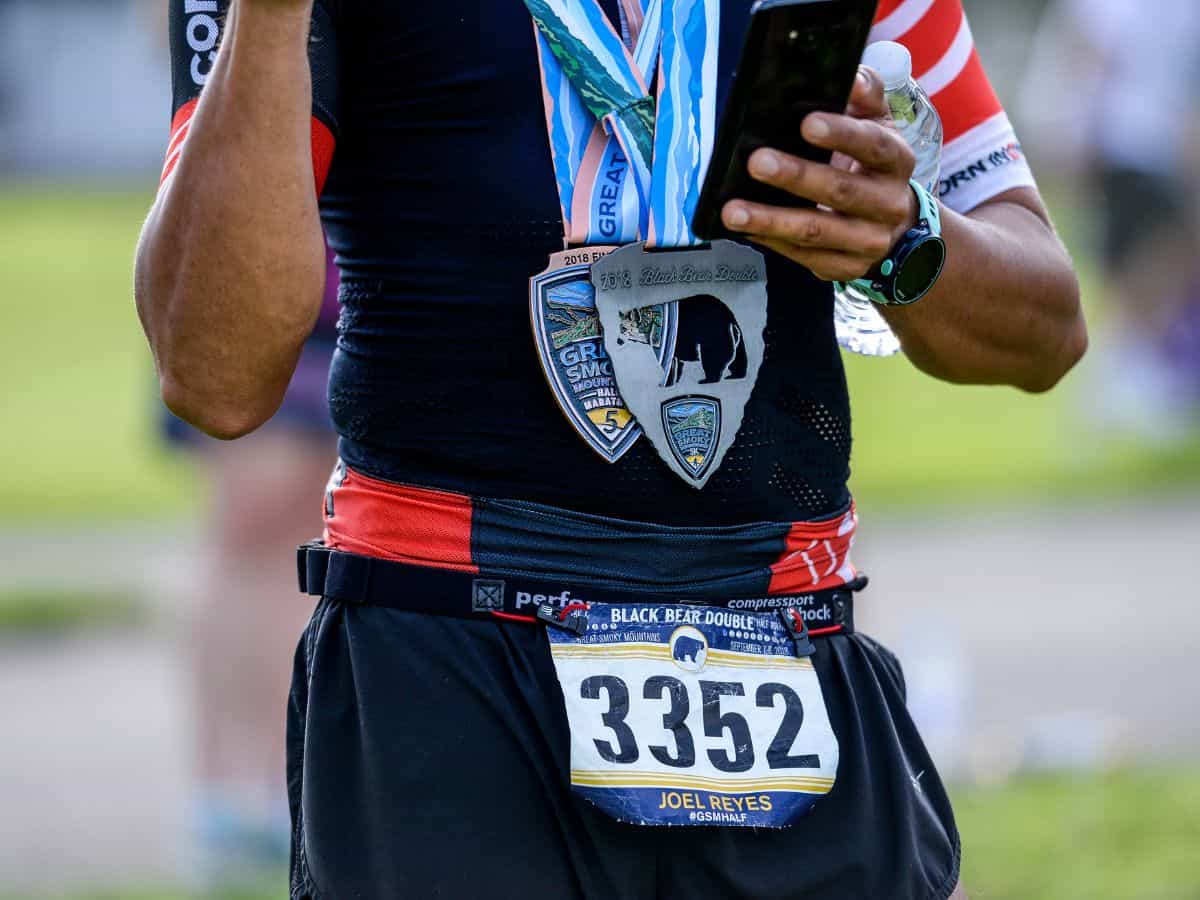 A man shows his medal for running the Great Smoky Mountains Half Marathon