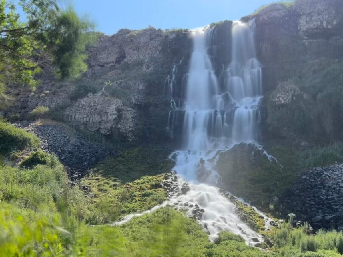 A waterfall cascades down the side of a cliff.