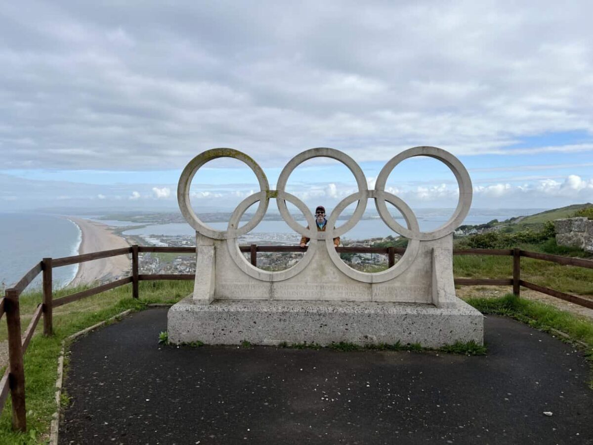 Scott McConkey, travel writer and founder of the Miles with McConkey travel blog, poses for a photo behind the Olympic rings sculpture in Portland, England.