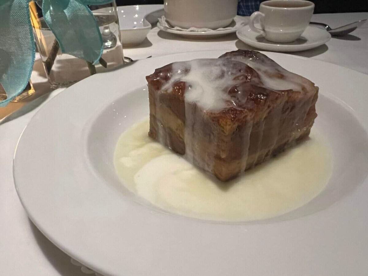 A plate of banana bread drizzled with icing sits on a table