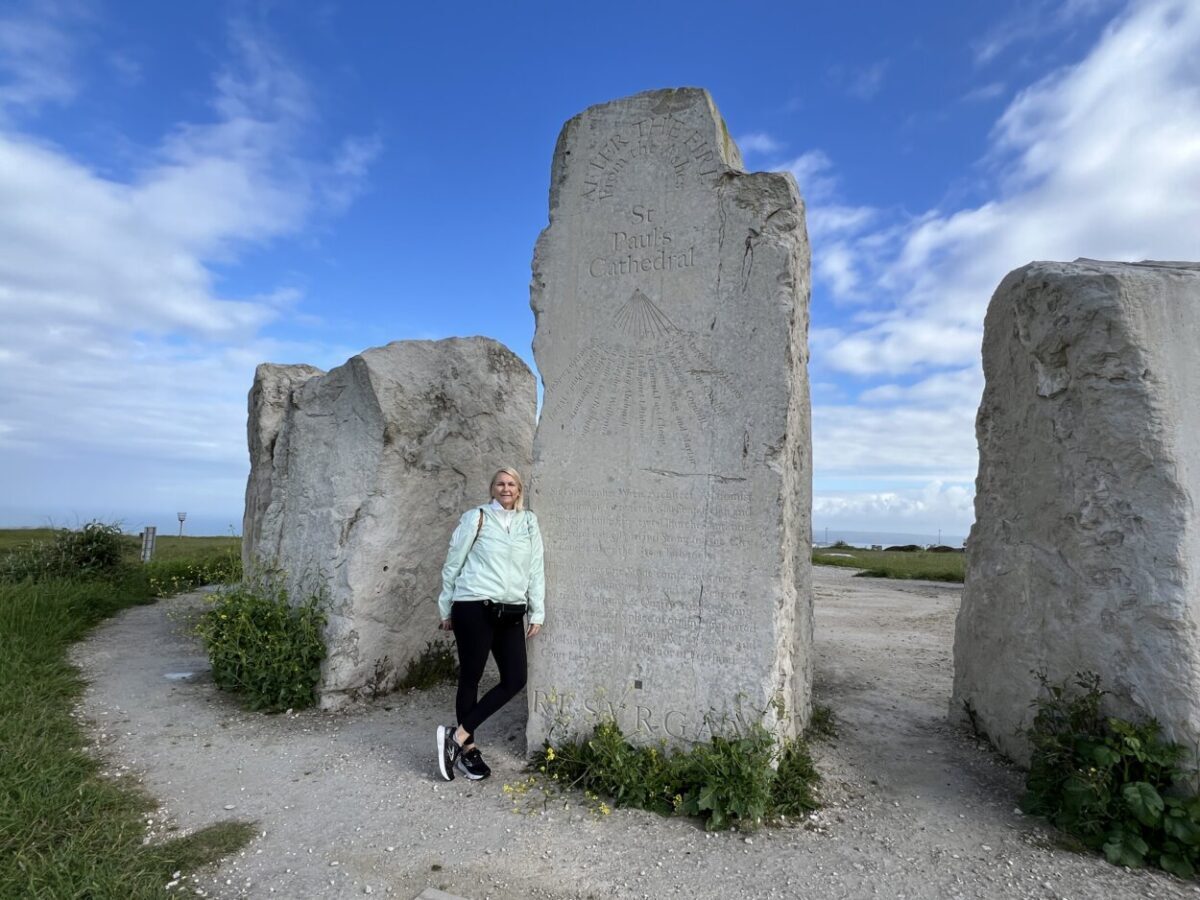 A woman poses for a picture next to a memory stone in Portland, England