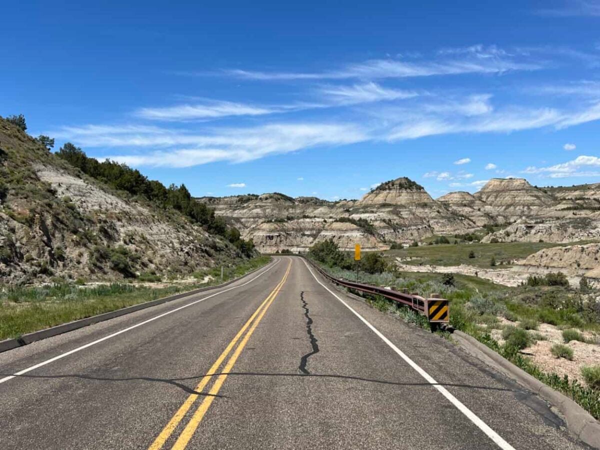 A road leads directly into badlands