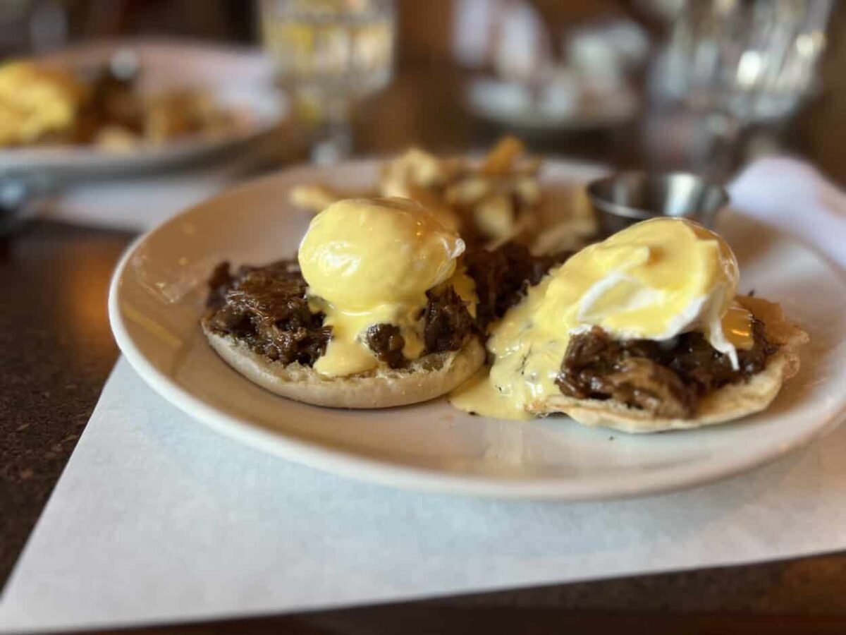 A plate English muffins topped with bison meat and poached eggs