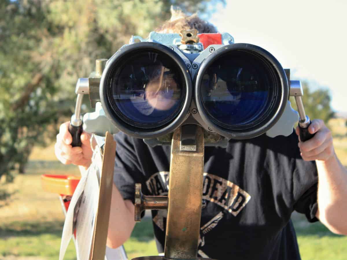 A man prepares to use giant binoculars for stargazing before the sky darkens