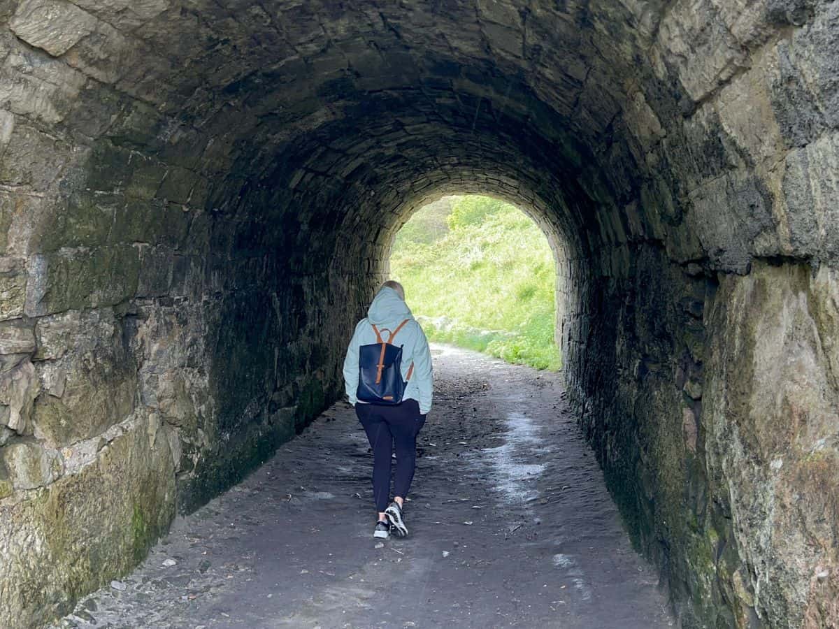 A woman walks through a tunnel in Tout Quarry, Dorset, UK