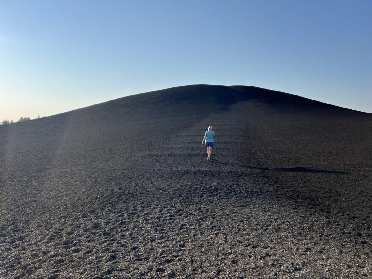 A woman climbs a cinder cone at Craters of the Moon, Idaho.