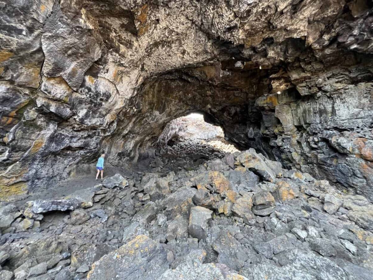 A woman walks through Indian Tunnel, a lava tube cave, in Craters of the Moon National Monument and Preserve, Idaho