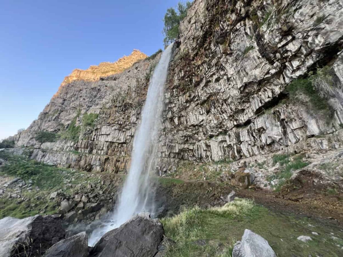 A path leads behind a waterfall.