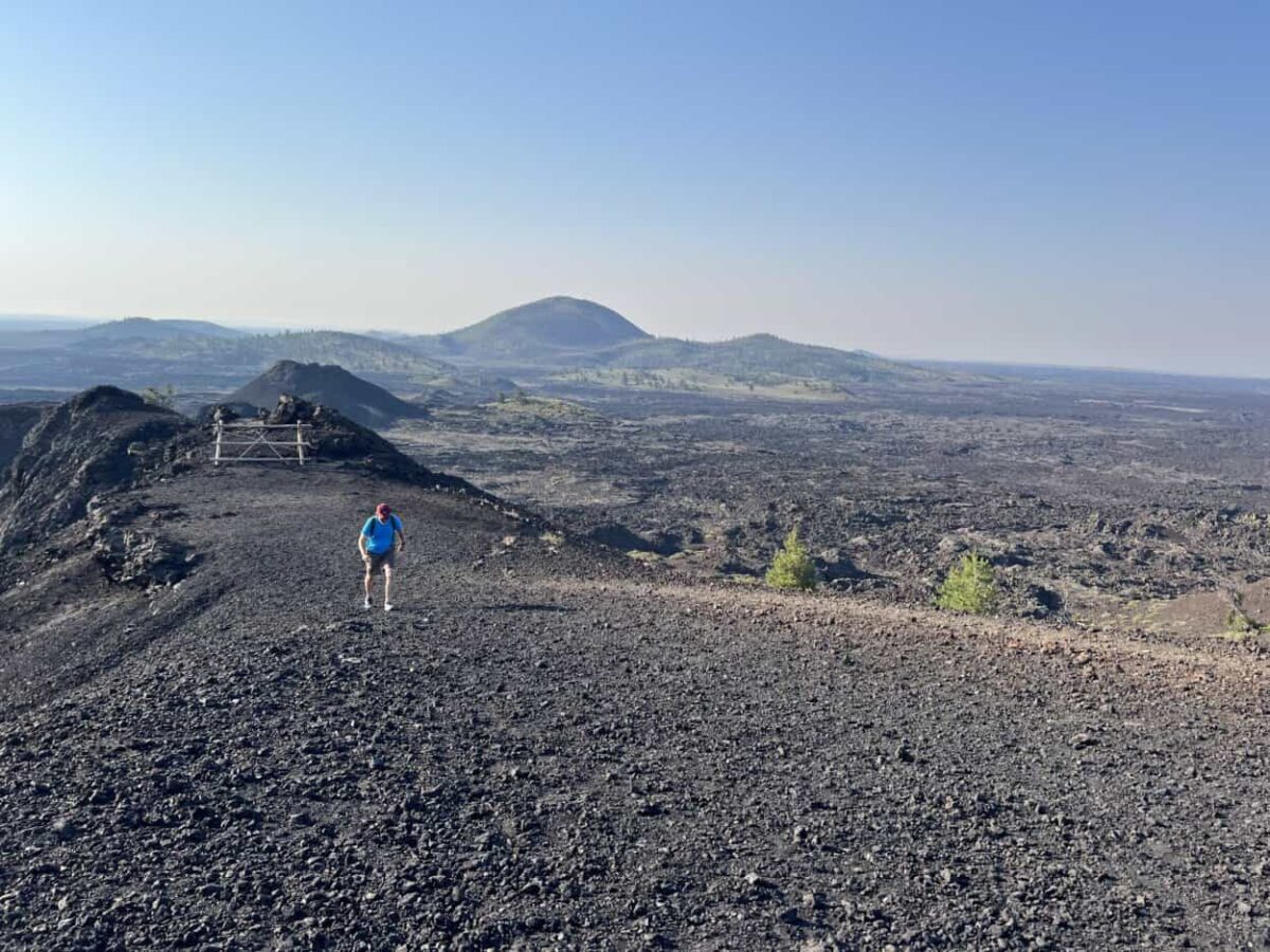 A man walks up lava terrain at Craters of the Moon in Idaho.