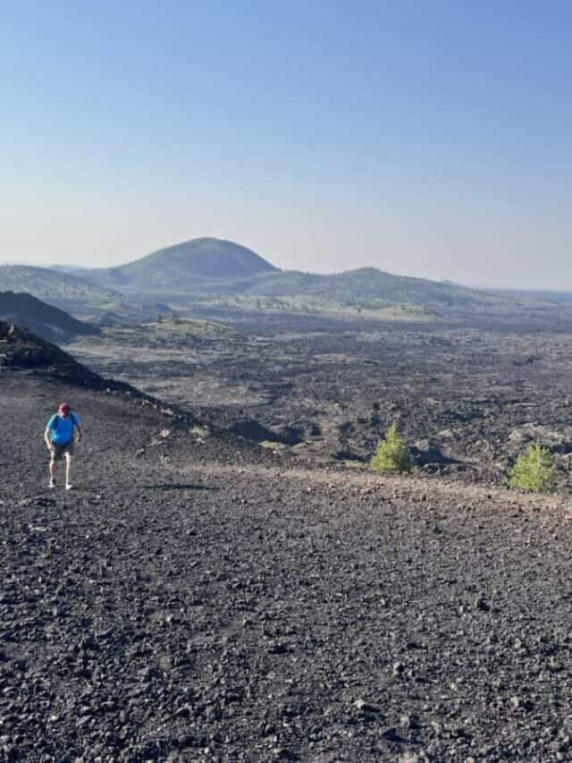 A man walks up lava terrain at Craters of the Moon in Idaho.