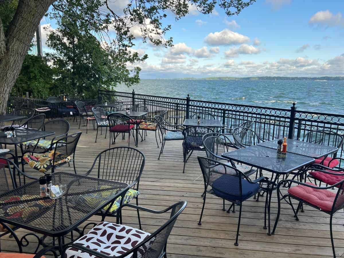 A Thousand Islands restaurant deck holds tables and chairs with a great view of the St. Lawrence River.