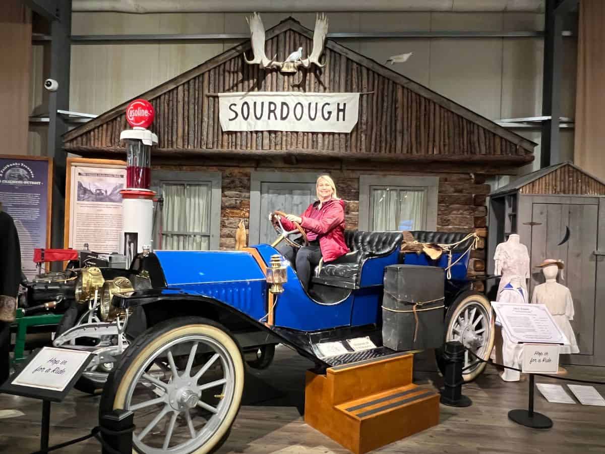 A woman sits in an antique car at the Fountainhead Antique Auto Museum in Fairbanks, AK.