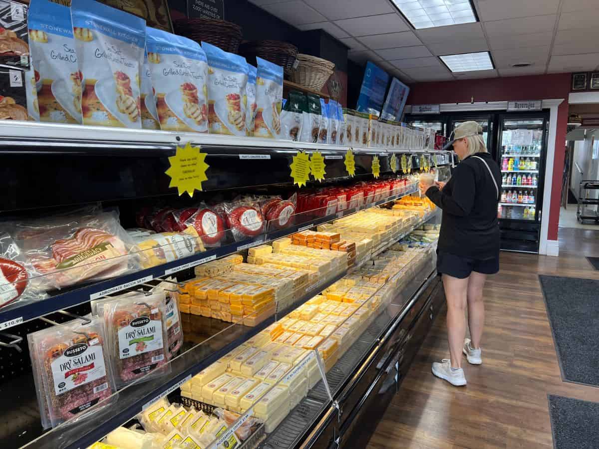 A woman shops for cheese in a cheese shop.