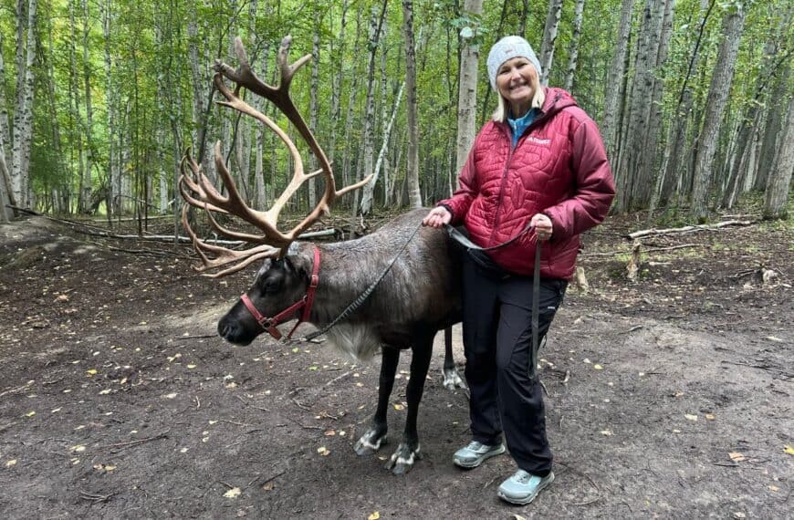 A woman poses for a picture with a reindeer at Running Reindeer Ranch in Fairbanks, AK.