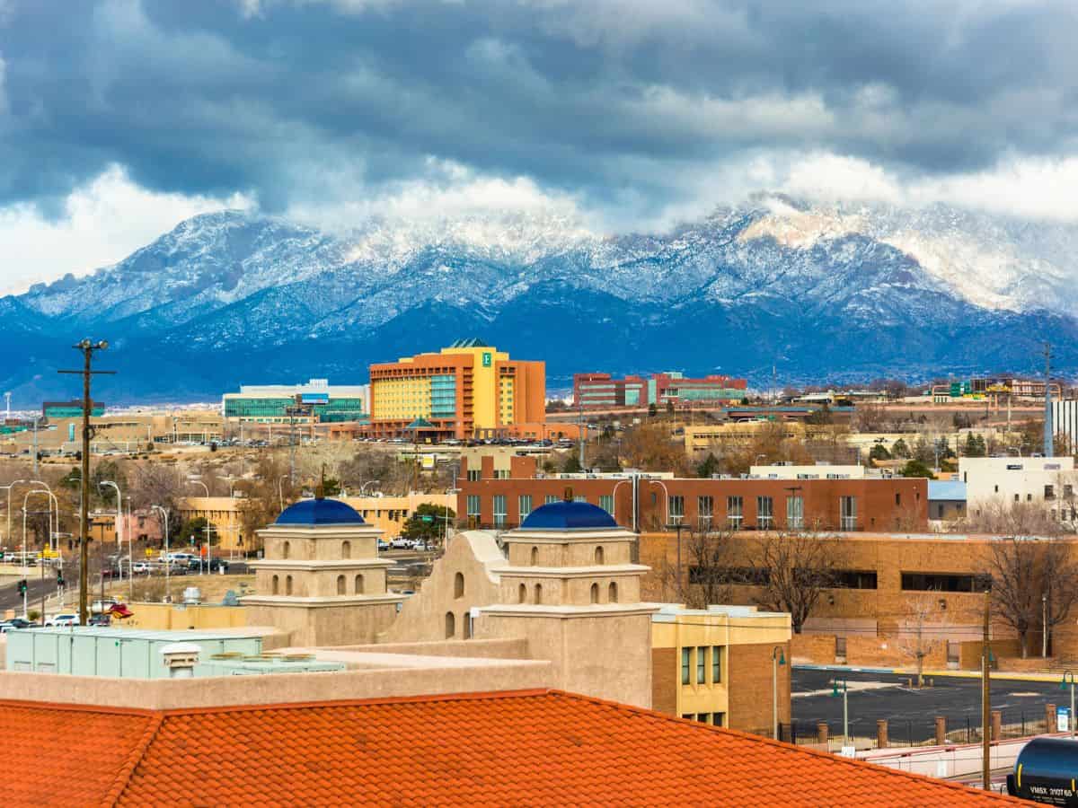 Mountains on the horizon tower over buildings in Albuquerque, New Mexico