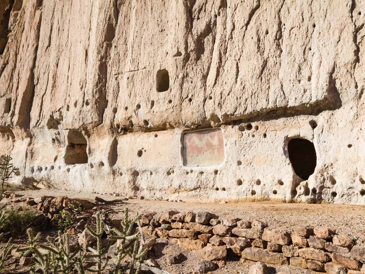 A cliff contains holes for windows and doors as made by an ancient civilization.