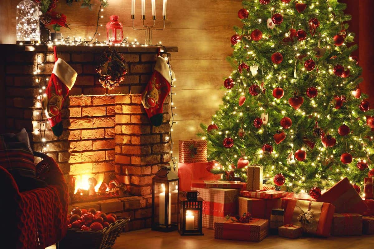 Wrapped gifts sit under a decorated Christmas tree near a fireplace.
