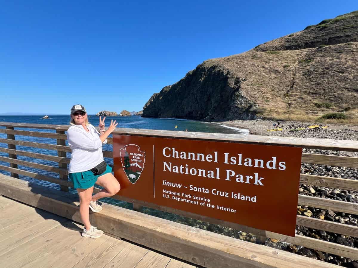 A woman poses for a picture next to the Channel Islands National Park sign