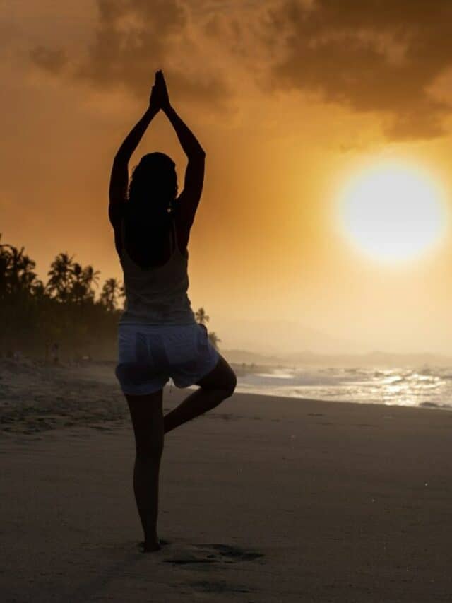 woman in white tank top and white shorts standing on beach during sunset