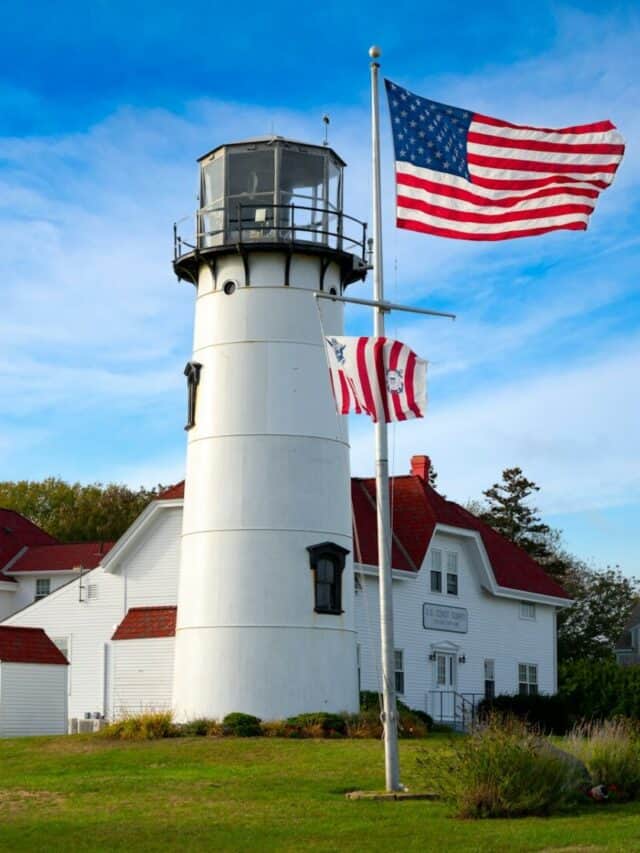 white and red concrete lighthouse near white and red house under blue sky during daytime
