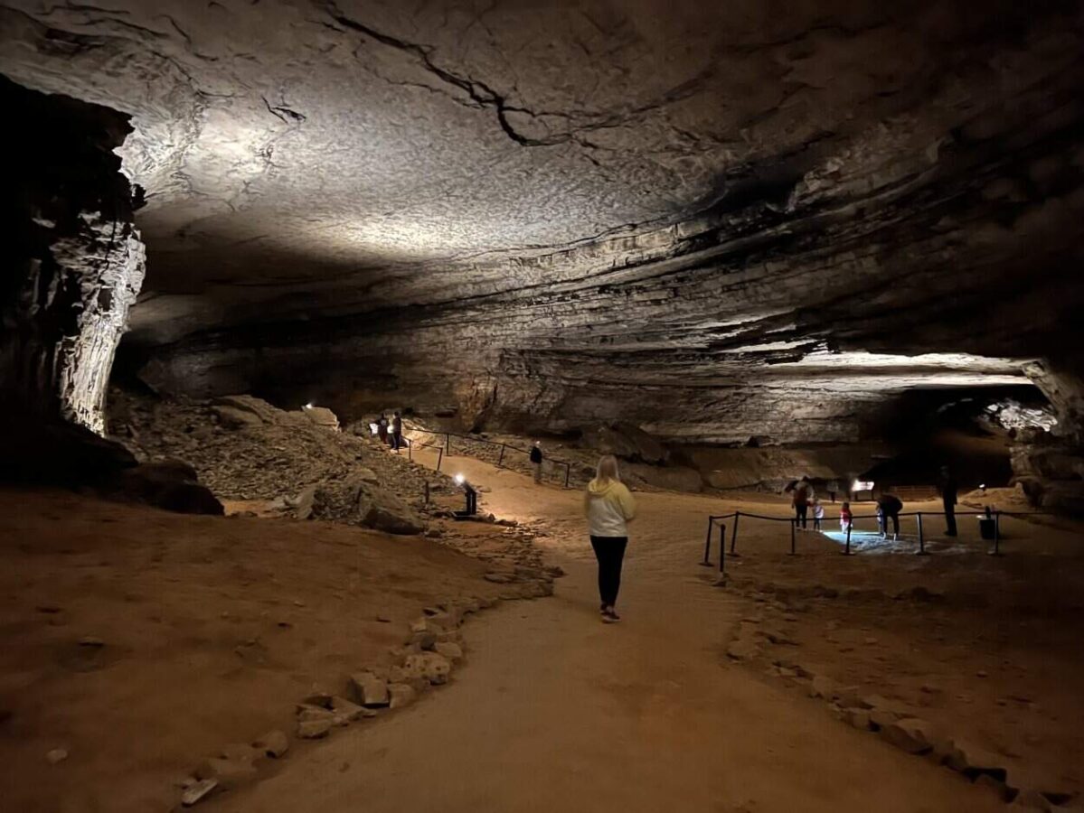 A woman pauses to take in the view of a massive cave