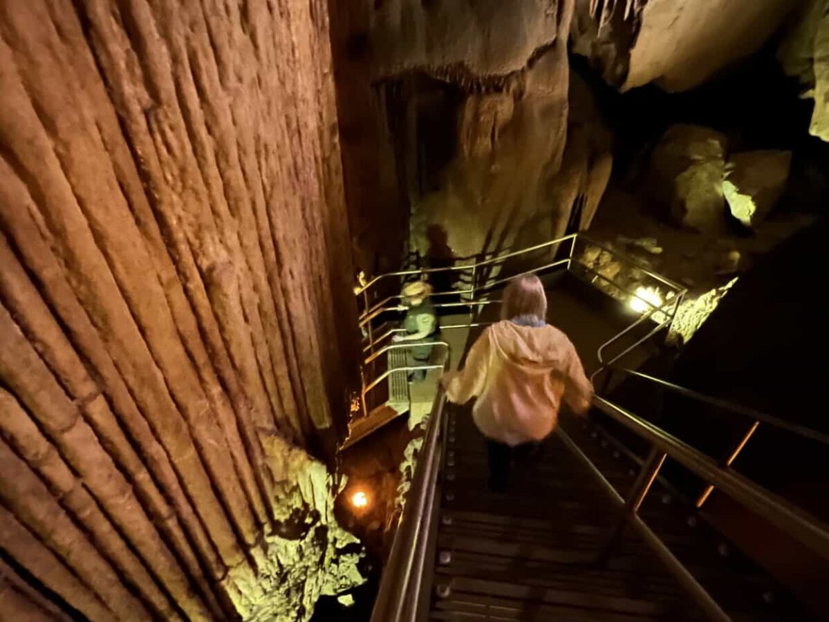 A woman descends a staircase in Mammoth Cave