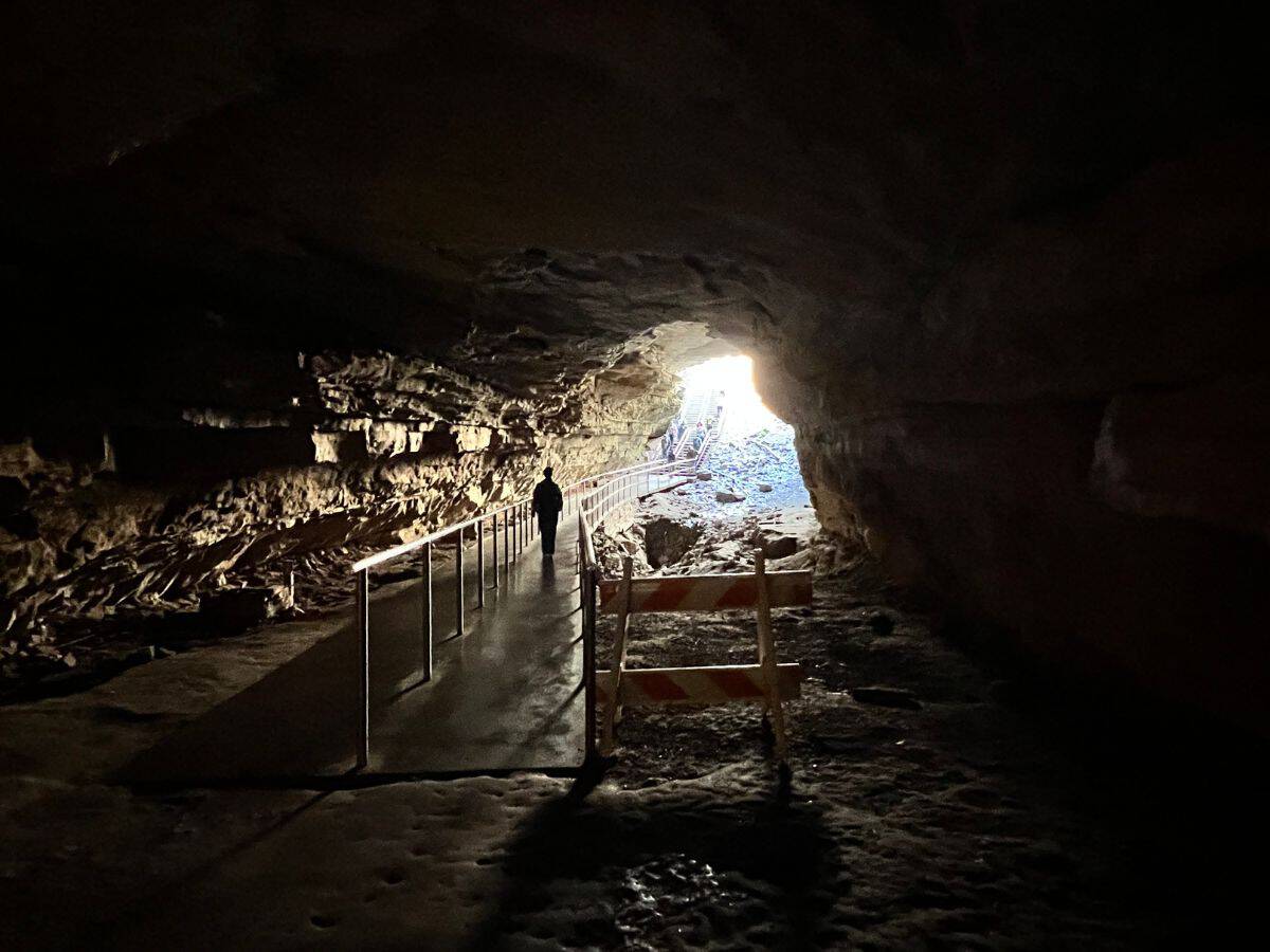 A man walks toward a cave entrance to exit Mammoth Cave.
