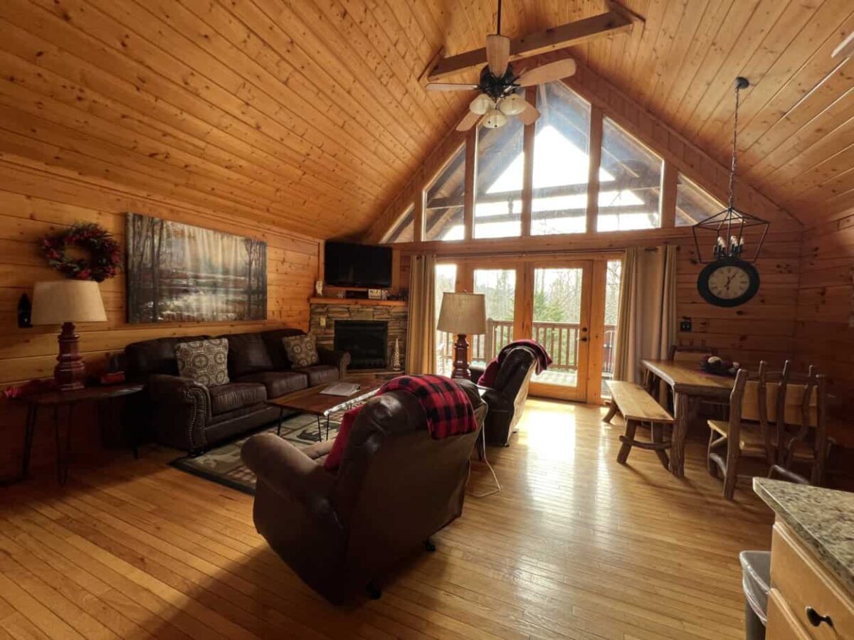 A sofa and two recliners inside a log cabin in Gatlinburg, TN
