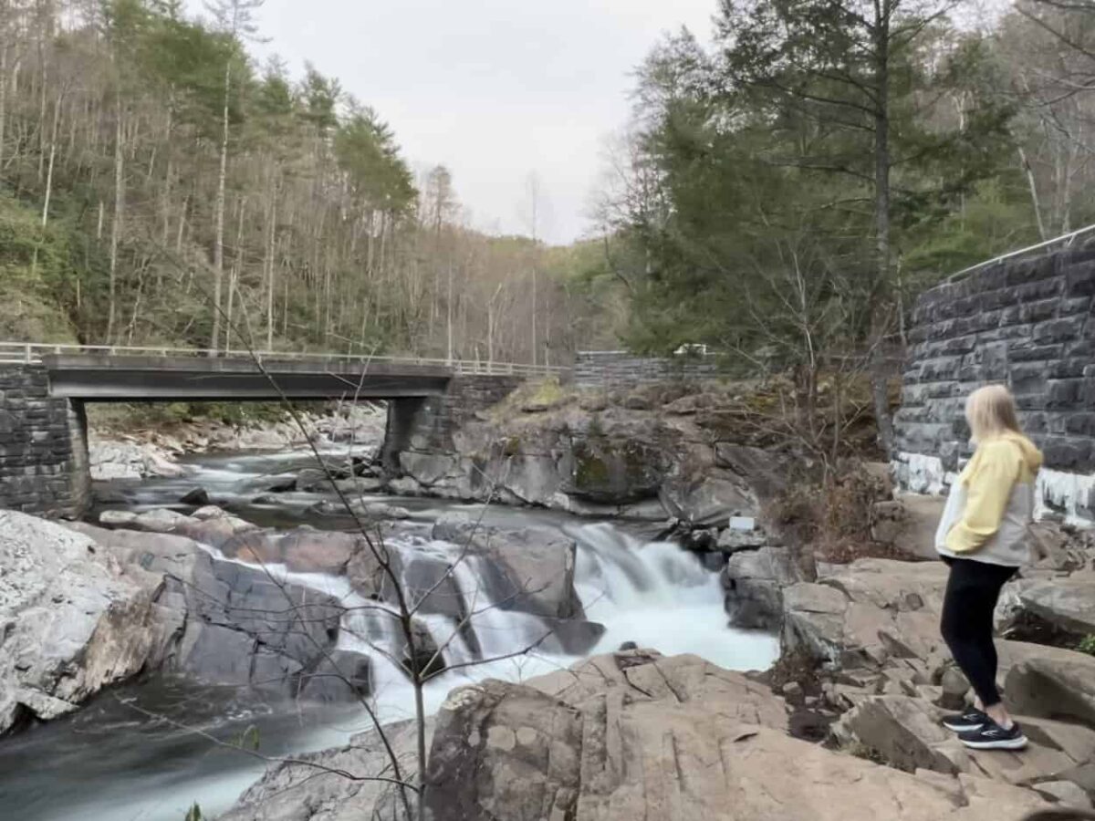 A woman looks at a roadside waterfall in the Smokies.