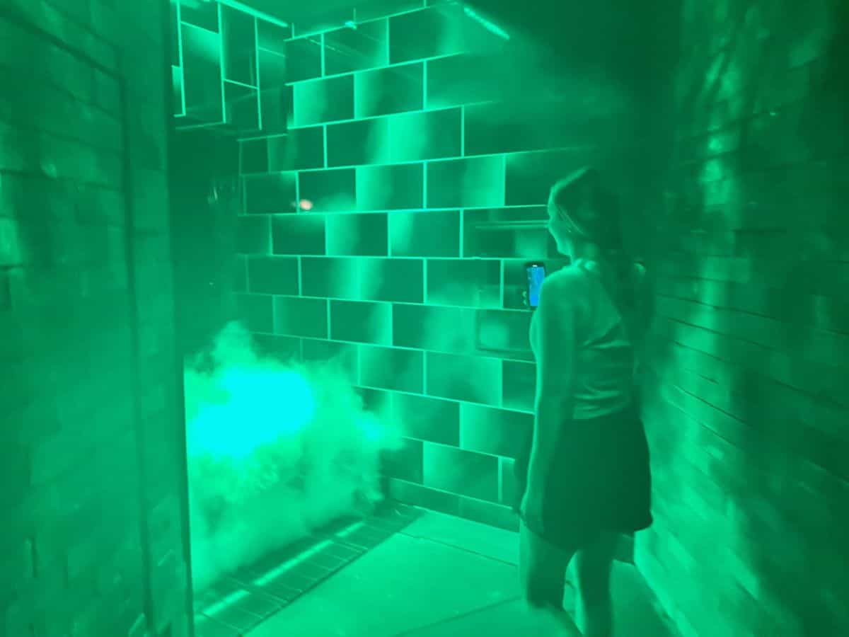 A girl walks toward a flash of green light and smoke in the Harry Potter and the Battle at the Ministry attraction.